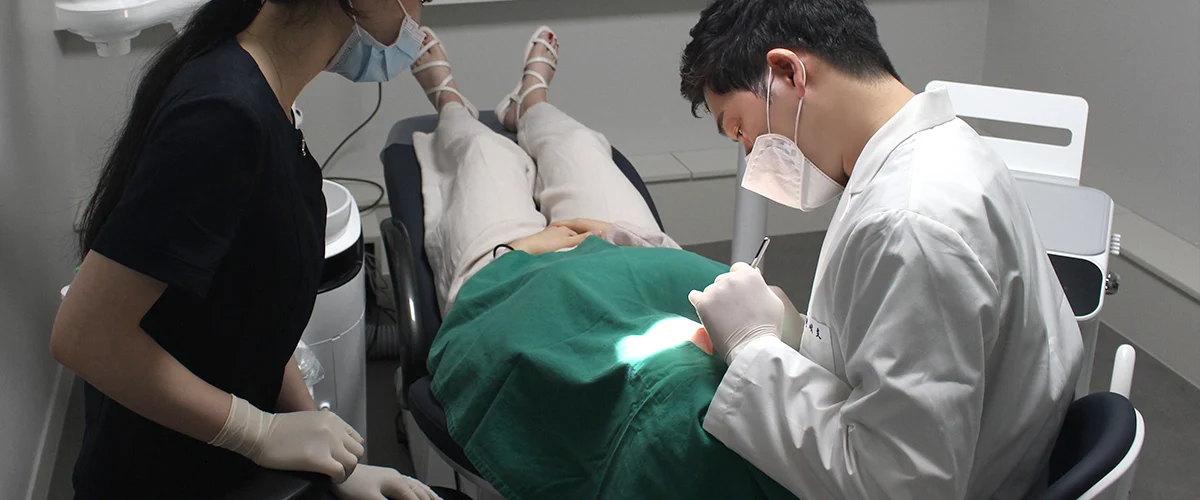 동그라미치과의원 진료실에서 원장과 진료 보조 인력이 무영등 아래 환자를 치료하는 모습.
